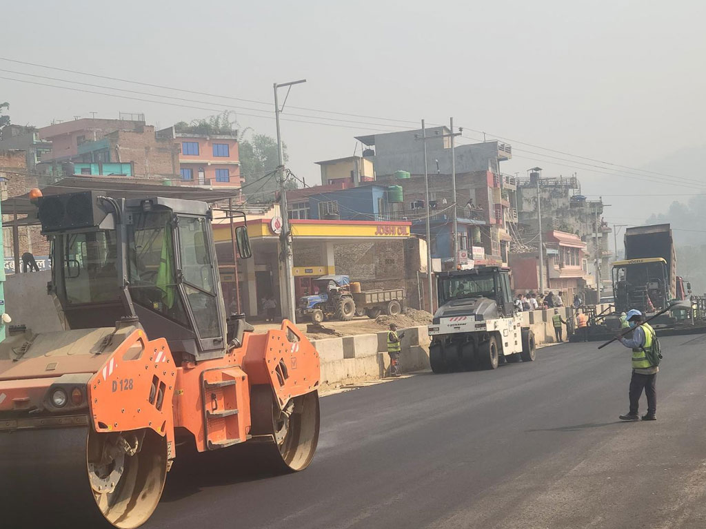 मुग्लिन पोखरा सडक : दमौली बजारस्थित बागबजार खण्डमा दोस्रो चरणको कालोपत्र सुरु